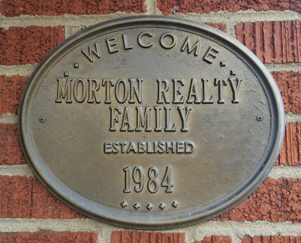 Embossed metal sign showing Morton Realty was established in 1984.